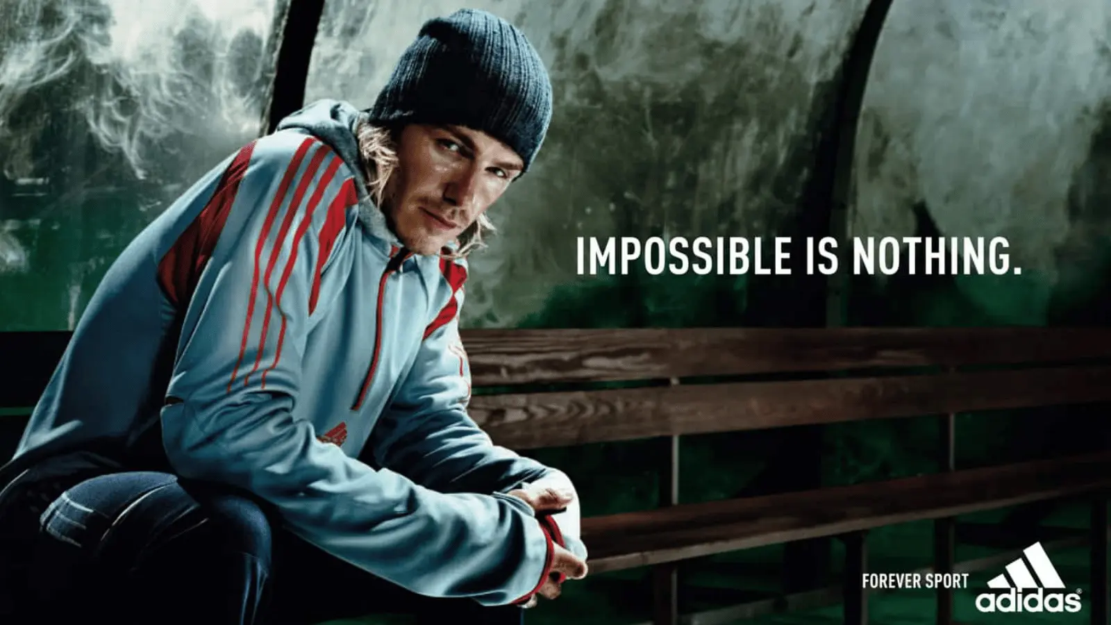 Athlete in Adidas gear with the slogan Impossible Is Nothing showcasing sports marketing examples in a motivational setting.
