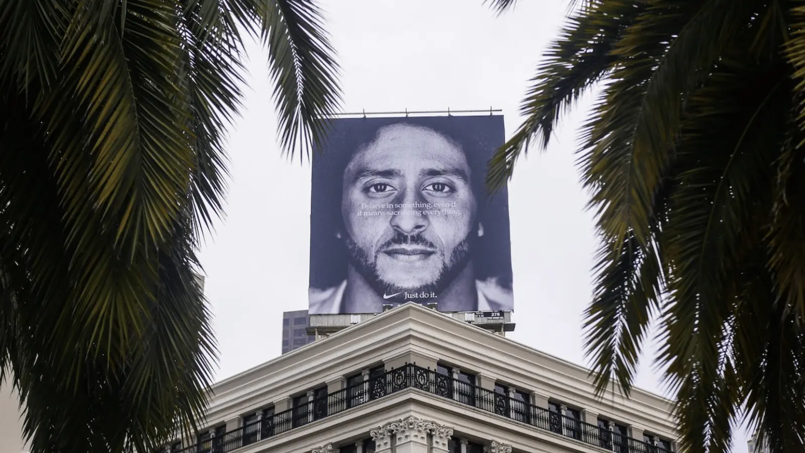 Nike billboard with "Believe in Something" message framed by palm trees for sports marketing examples of bold advertising.